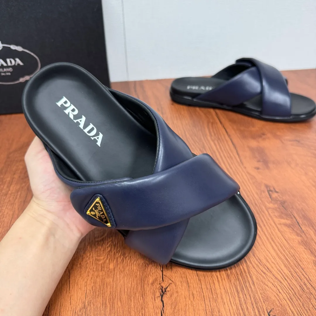 Batch 580 Prada/Prada's new men's leather cross slippers. Velcro closure can finely adjust the size. Calf leather light luxury slippers. Thick soft calf leather wraps the upper. Fat but soft rubber lazy style, soft and comfortable, excellent foot feel. Genuine leather bottom layer, cross style, with a Velcro closure buckle, easy to adjust the appropriate size, and a perfect fit for the wearing experience. The enamel gold triangle logo highlights the brand's classic features. Lightweight rubber thin sole, high foot comfort! Complete package! Size: 39-40-41-42-43-44-45 Leather shoe size Item number: 2X7132 Blue